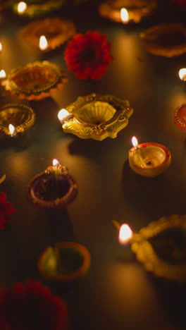 Vertical-Video-Shot-Of-Diya-Oil-Lamps-Celebrating-Festival-Of-Diwali-Burning-In-The-Dark